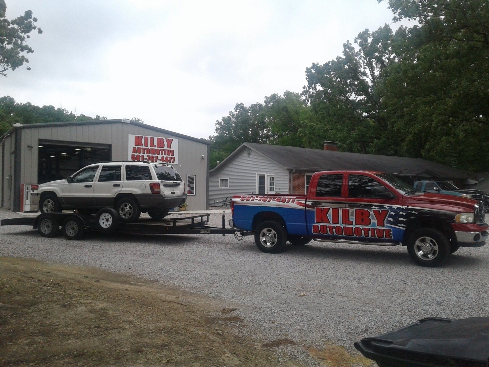 The Kilby Automotive shop truck hauling a customer's Jeep outside the shop on Lancaster Rd